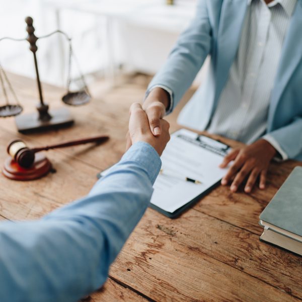 Law, consultation, agreement, contract, lawyer or  attorney shakes hands to agree on the client's offer to be hired to fight the parties in court